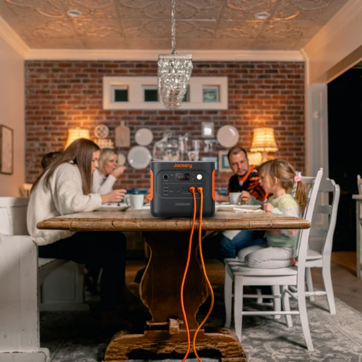 Family enjoying a meal at a long table with Jackery Explorer 2000 v2 Portable Power Station nearby