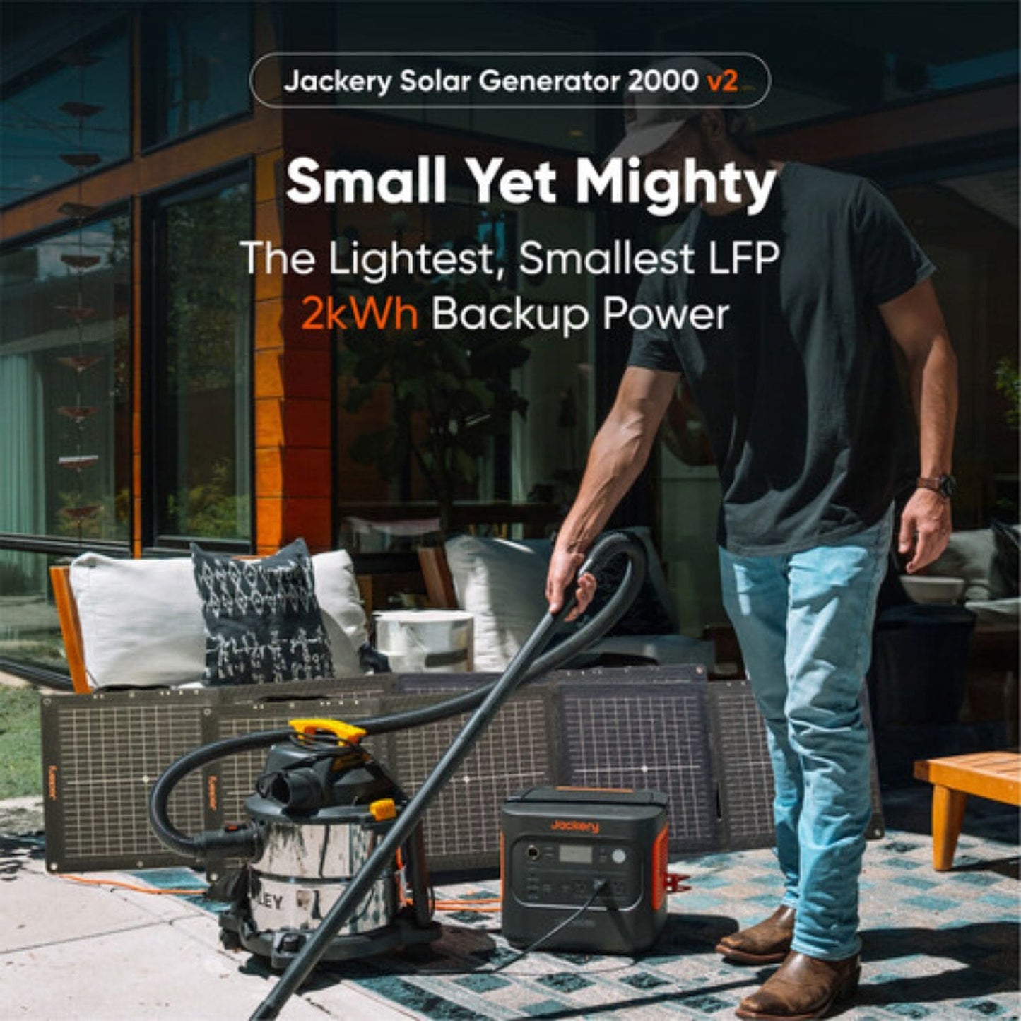 Jackery Explorer 2000 v2 Portable Power Station with vacuum plugged in and solar panel in the background